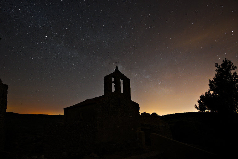 Drapé de lumière • La Voie lactée enveloppe le clocher de la chapelle du village abandonné d’Opoul-Périllos, Pyrénées Orientales, France, 7 avril 2014